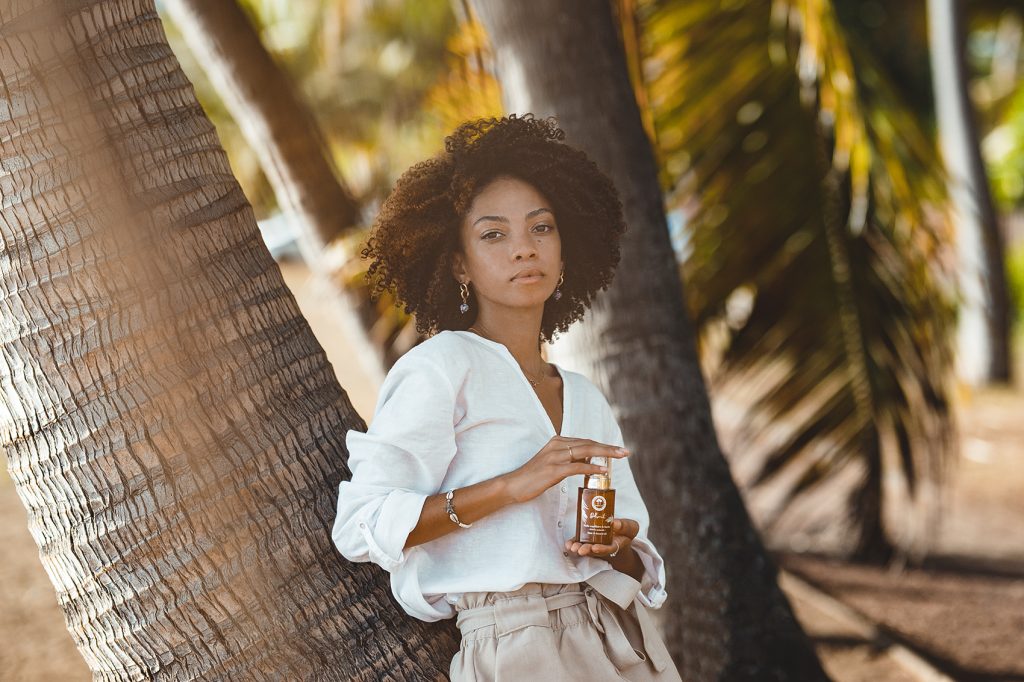 Photo d'une modèle posée sur un cocotier à proximité de la plage